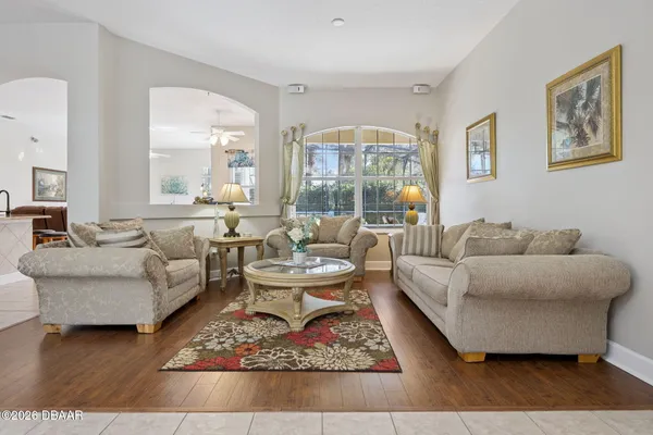 a living room with furniture a rug a lamp and a large window