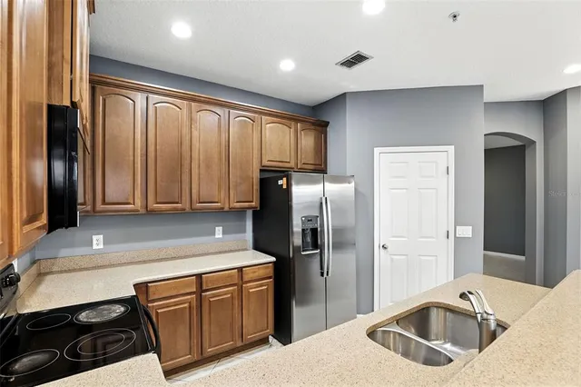 a kitchen with granite countertop a refrigerator and a sink