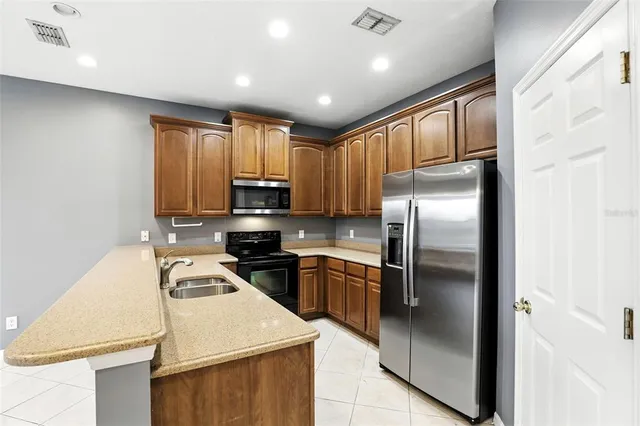 a kitchen with kitchen island granite countertop stainless steel appliances cabinets a sink and a counter top space