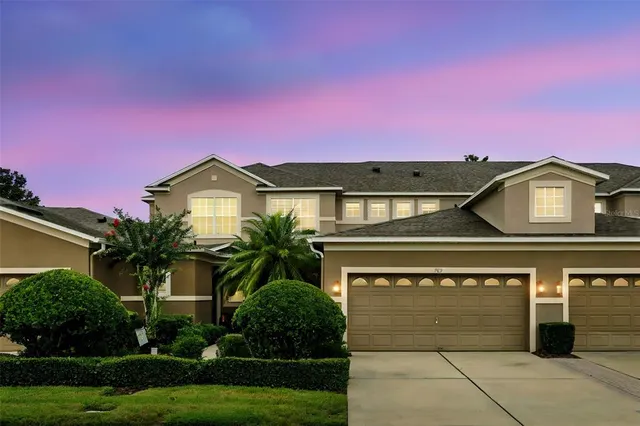 a view of a house with a yard and potted plants