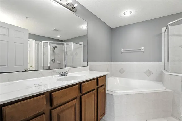 a bathroom with a tub a sink and mirror