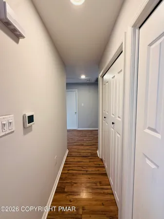 a view of a hallway with wooden floor and staircase