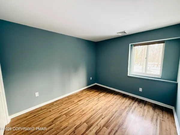 a view of a room with wooden floor and fan