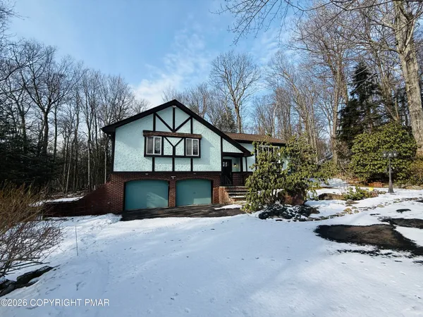 a view of a house with a yard covered with snow in front of house