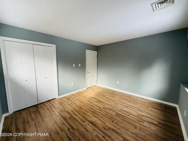a view of empty room with wooden floor
