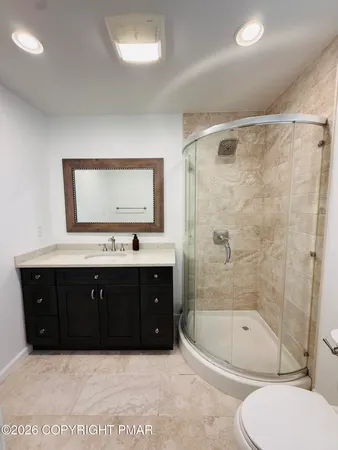 a bathroom with a bathtub sink vanity mirror and toilet