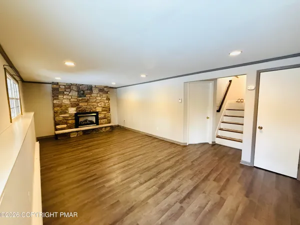 a view of a room with wooden floor and windows