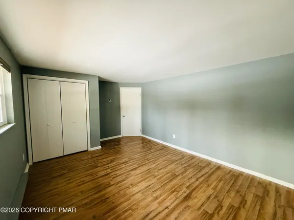 a view of empty room with wooden floor