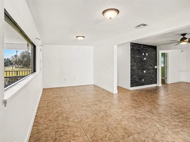 an empty room with large mirror and windows