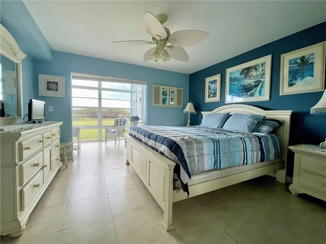 a spacious bedroom with a bed and a chandelier