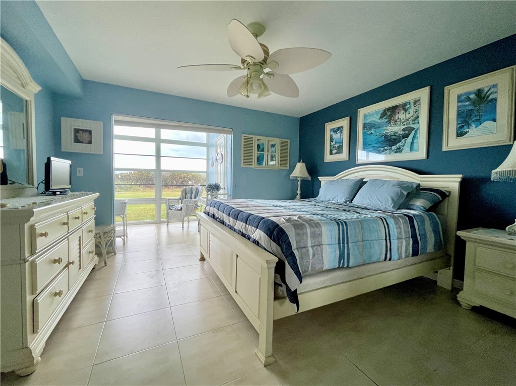 5400 A1a Highway, Unit A2 Vero Beach, FL 32963 - Photo 18 of 28 a spacious bedroom with a bed and a chandelier