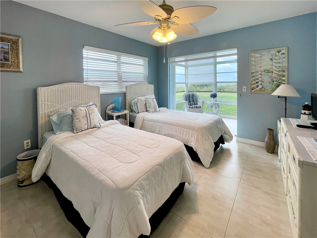 5400 A1a Highway, Unit A2 Vero Beach, FL 32963 - Photo 21 of 28 a bedroom with two beds and a chandelier