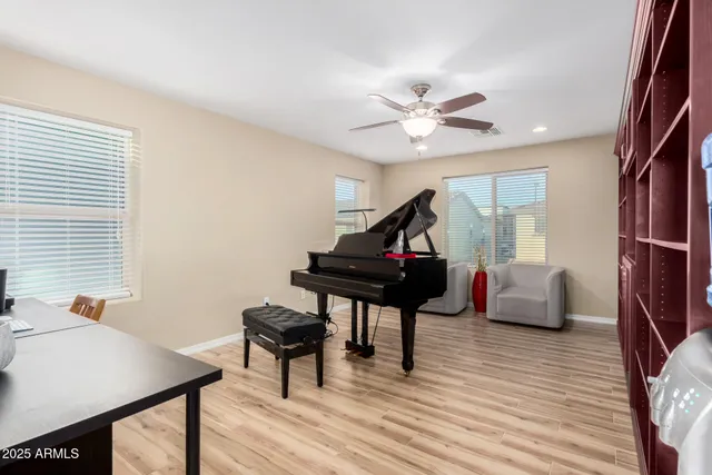 a living room with furniture a piano and wooden floor
