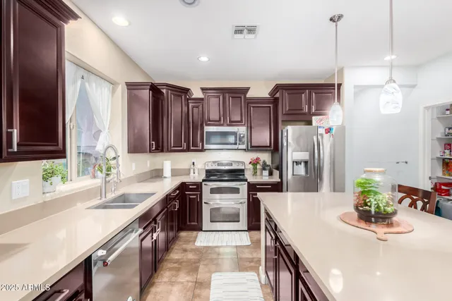 a kitchen with stainless steel appliances granite countertop a sink stove and refrigerator
