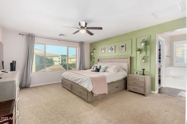 a spacious bedroom with a large bed and a chandelier