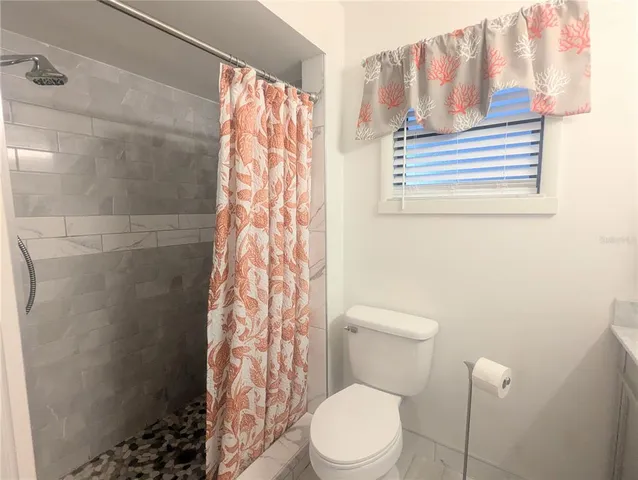 a white toilet sitting next to a shower curtain