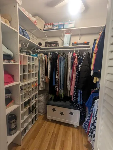a view of walk in closet with clothes and shoes