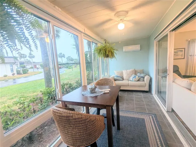 a dining room with furniture and a floor to ceiling window