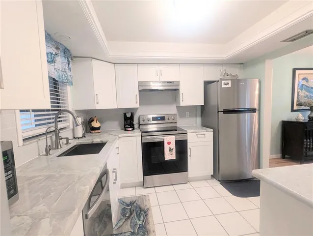 a kitchen with a stove a refrigerator and a sink