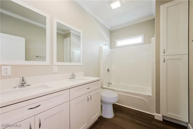 a bathroom with a granite countertop sink a toilet and shower