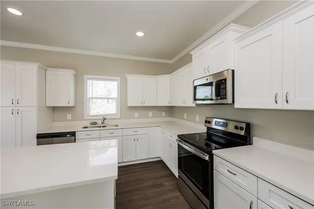 a kitchen with a sink white cabinets and black appliances