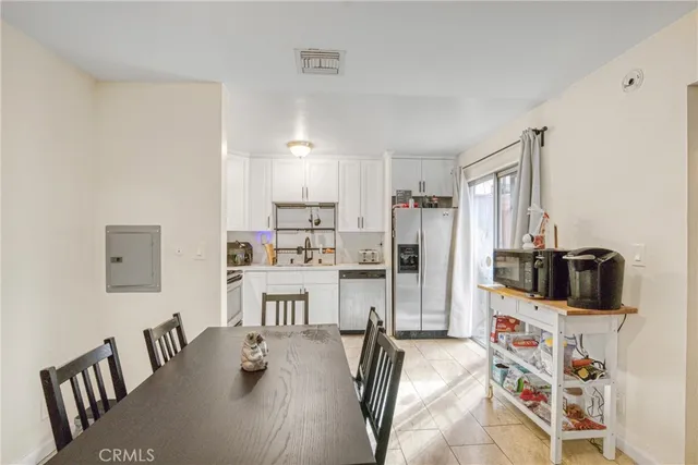 a kitchen with stainless steel appliances wooden floor and refrigerator