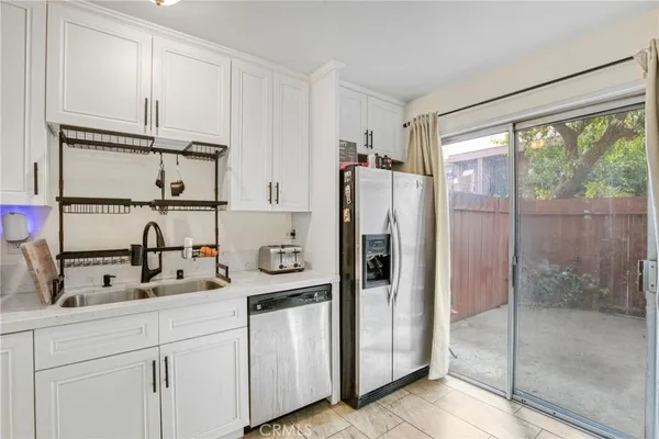 a kitchen with appliances a refrigerator and cabinets