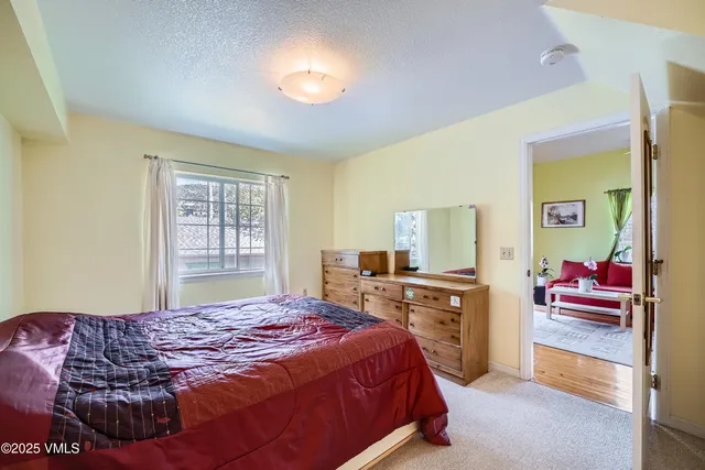 a bedroom with a bed and a dresser with mirror