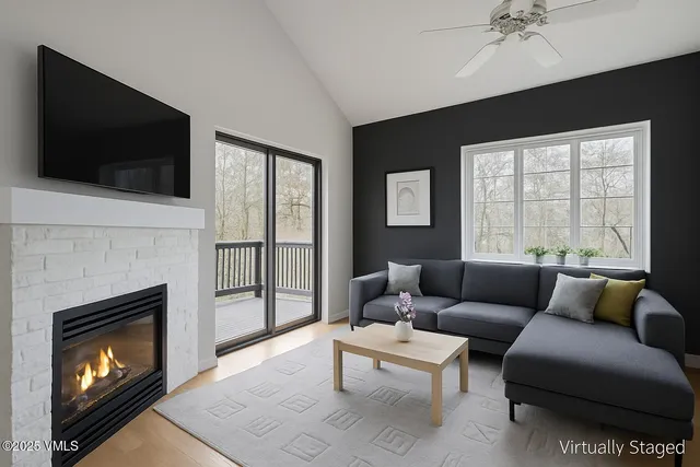 a living room with furniture a flat screen tv and a fireplace