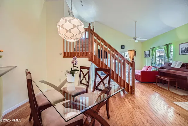 a view of a dining room with furniture a chandelier and wooden floor
