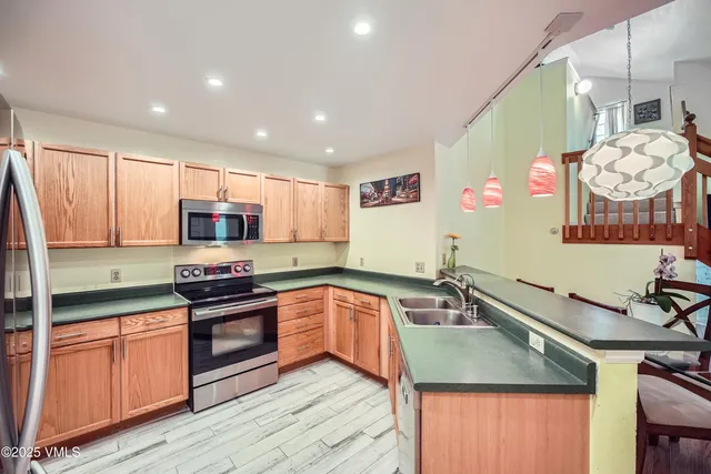 a kitchen with stainless steel appliances a sink a stove top oven a counter space and cabinets