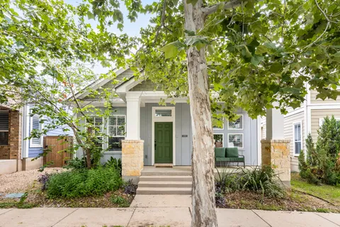 a front view of a house with a tree
