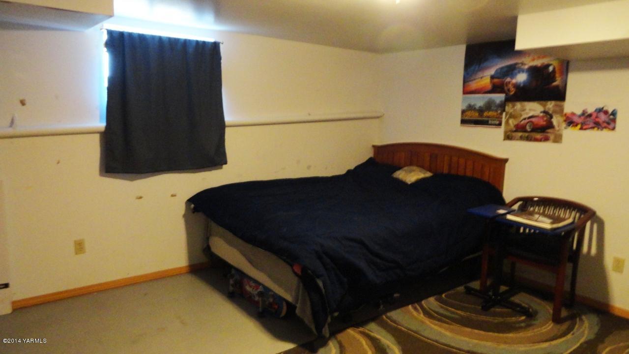 3551 McDonald Road Wapato, WA 98951 - Photo 7 of 10 a bed room with a bed and a chair