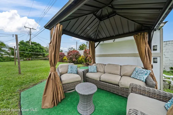 a view of a patio with couches chairs and a yard