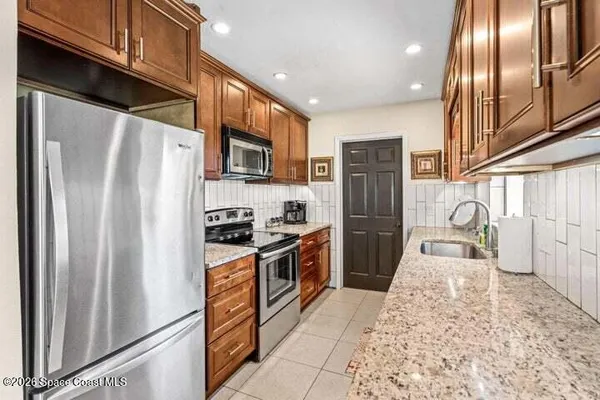 a kitchen with stainless steel appliances granite countertop a refrigerator stove and sink