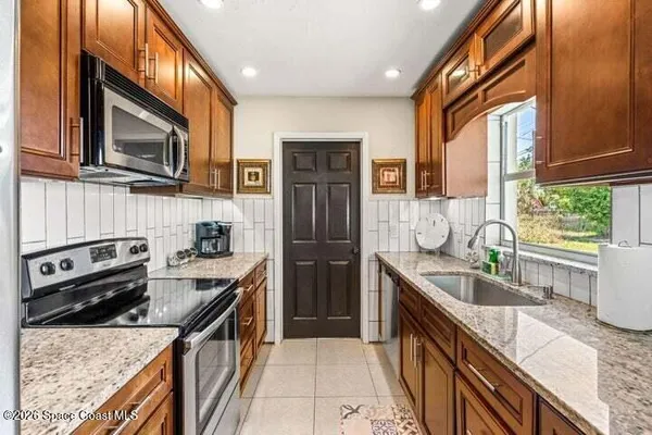 a kitchen with stainless steel appliances granite countertop a refrigerator a stove top oven a sink and dishwasher
