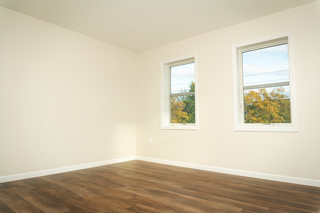 199 Clemente Street Holyoke, MA 01040 - Photo 11 of 16 an empty room with wooden floor and windows