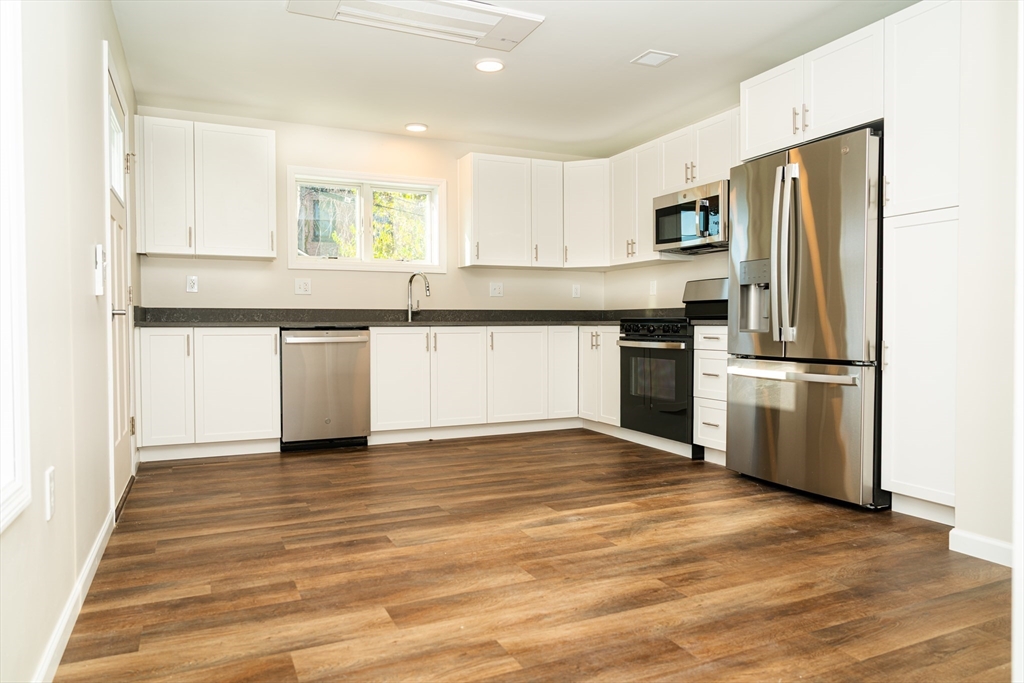 199 Clemente Street Holyoke, MA 01040 - Photo 5 of 16 a kitchen with granite countertop a refrigerator and a stove top oven