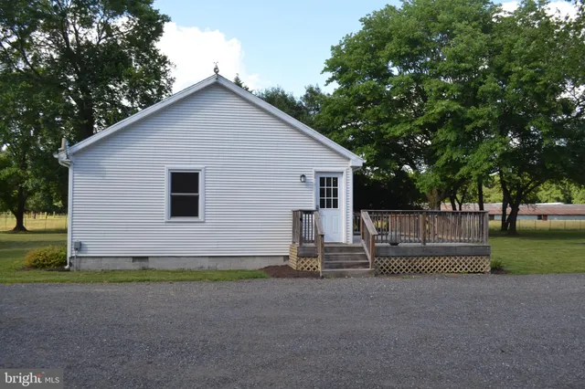 a view of backyard with wooden fence and large trees
