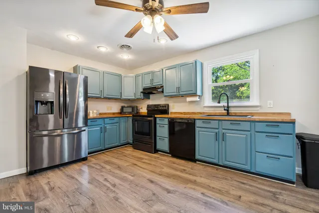 a kitchen with stainless steel appliances granite countertop a refrigerator a sink dishwasher a stove and a refrigerator