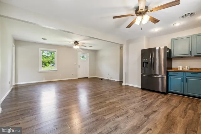 a view of a kitchen with a sink a ceiling fan and refrigerator