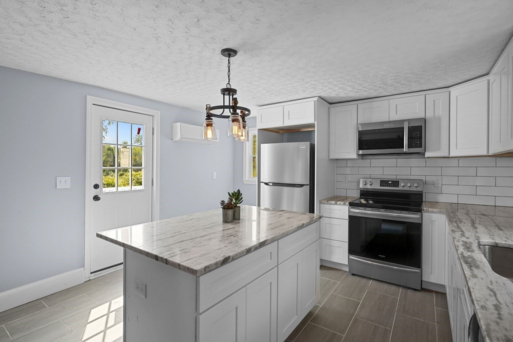 780 Williams Street Dighton, MA 02764 - Photo 7 of 39 a kitchen with granite countertop a refrigerator a stove a microwave and island