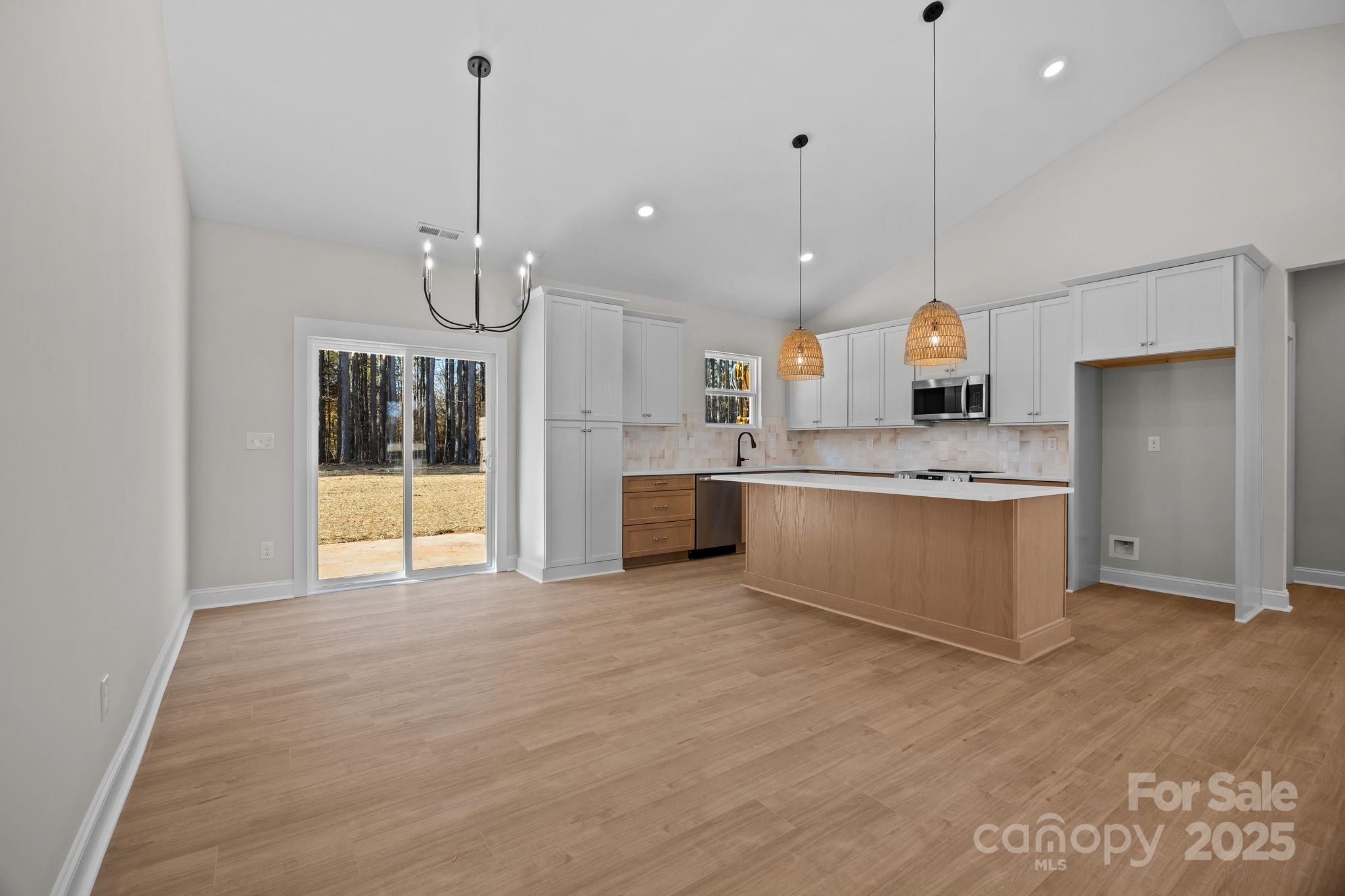 2307 Lee Lawing Road Lincolnton, NC 28092 - Photo 13 of 40 a large kitchen with kitchen island a stove a sink a center island and wooden floor