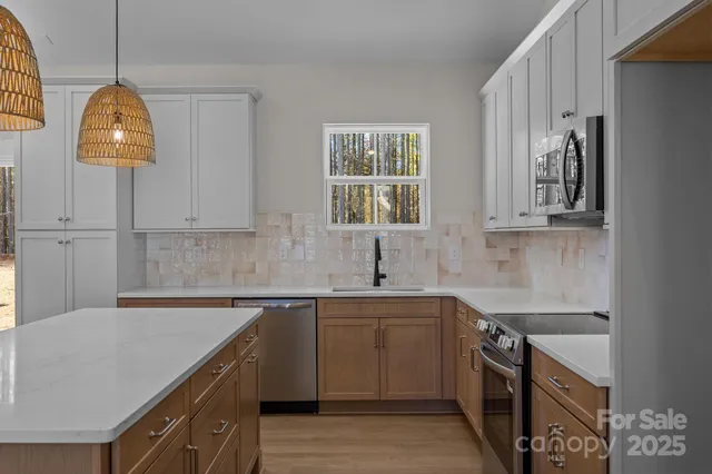 a kitchen with stainless steel appliances a sink a stove and a refrigerator