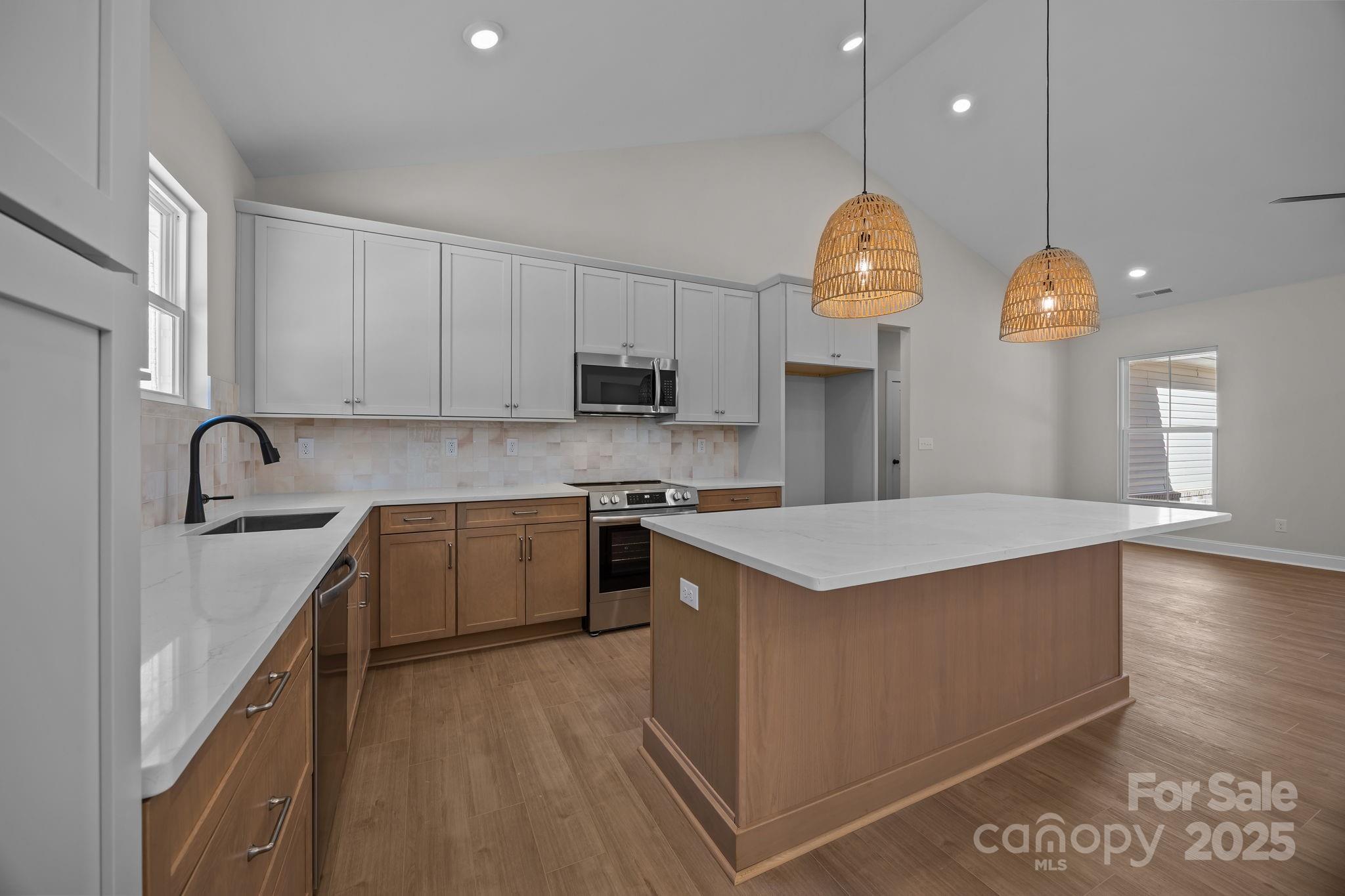 2307 Lee Lawing Road Lincolnton, NC 28092 - Photo 20 of 40 a kitchen with kitchen island granite countertop a stove a sink a refrigerator and a wooden cabinets