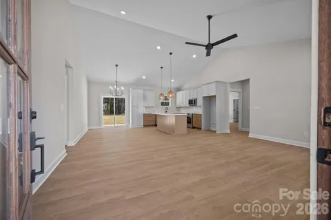 a large white kitchen with a sink and refrigerator