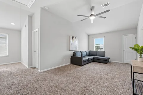 a living room with furniture and a ceiling fan