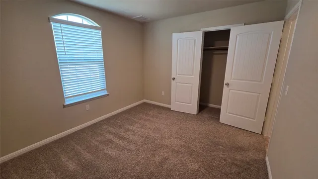 an empty room with windows and closet