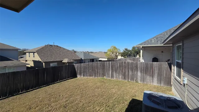 a view of a backyard with a barbeque and wooden fence