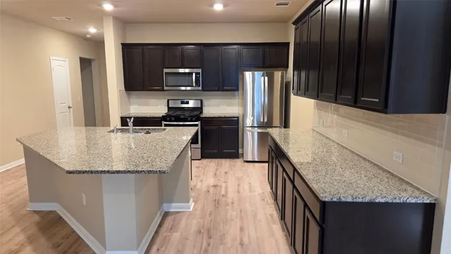 a kitchen with granite countertop stainless steel appliances and wooden cabinets